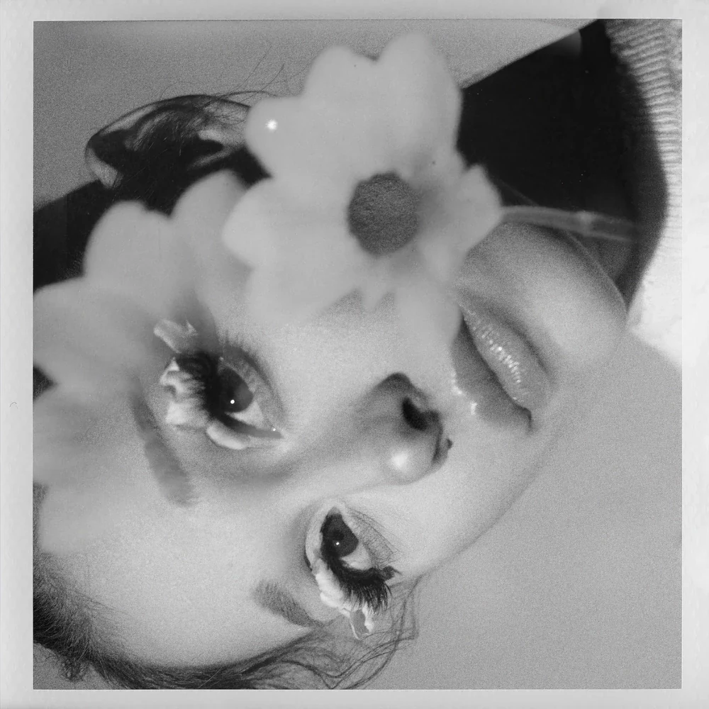 Ariana Grande framed by a flower on the petal cover